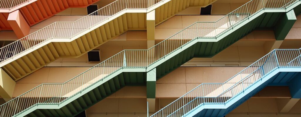 Eine lebendige und optisch ansprechende Treppe in einem Mehrfamilienhaus, die in ihrem Design eine nachhaltige Verbesserung aufweist.